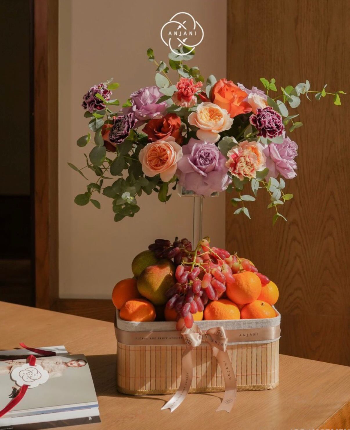 The Anjani Bloom and Bite Bar, a display of fruit cups and fresh flowers at a wedding event